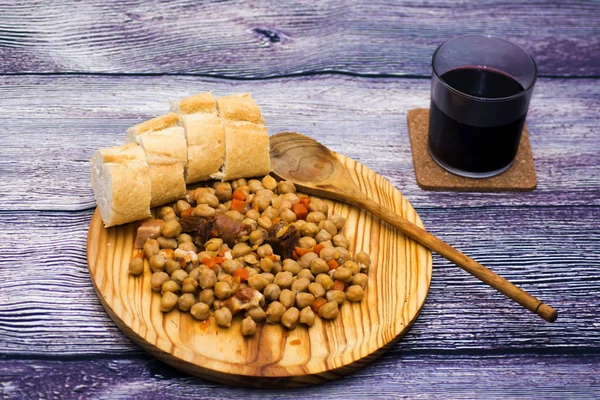 Dušené maso na talíři na dřevěný stůl s chlebem a sklenici Madrid — Stock fotografie