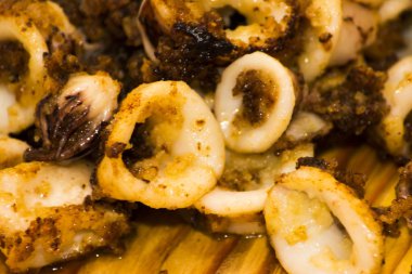 Fried squids ve shipirons ahşap plaka üzerinde limonlu