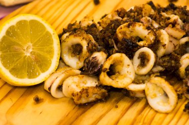 Fried squids ve shipirons ahşap plaka üzerinde limonlu