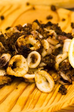 Fried squids ve shipirons ahşap plaka üzerinde limonlu