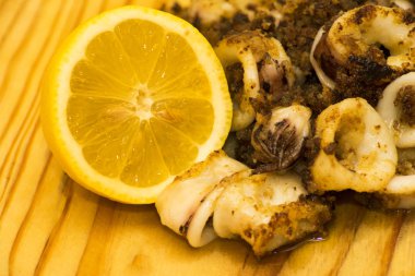 Fried squids ve shipirons ahşap plaka üzerinde limonlu