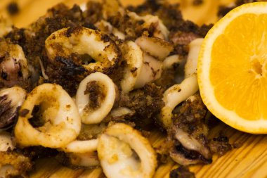 Fried squids ve shipirons ahşap plaka üzerinde limonlu
