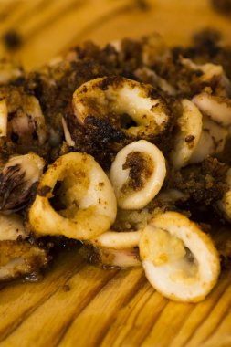 Fried squids ve shipirons ahşap plaka üzerinde limonlu