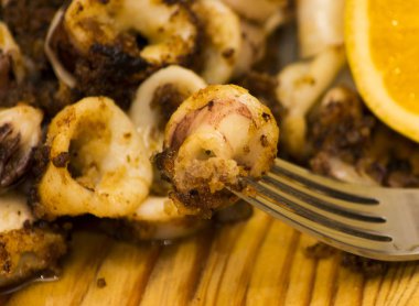 Fried squids ve shipirons ahşap plaka üzerinde limonlu