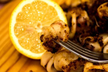 Fried squids ve shipirons ahşap plaka üzerinde limonlu