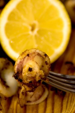 Fried squids ve shipirons ahşap plaka üzerinde limonlu