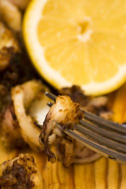 Fried squids ve shipirons ahşap plaka üzerinde limonlu