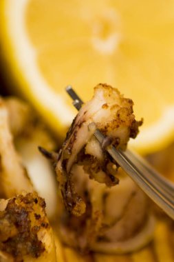 Fried squids ve shipirons ahşap plaka üzerinde limonlu