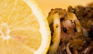 Fried squids ve shipirons ahşap plaka üzerinde limonlu