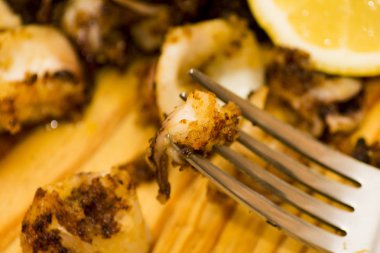 Fried squids ve shipirons ahşap plaka üzerinde limonlu