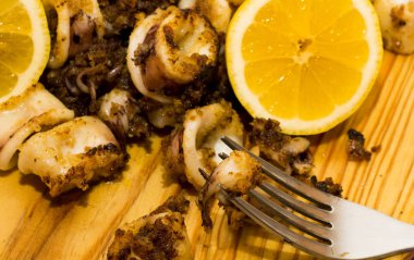 Fried squids ve shipirons ahşap plaka üzerinde limonlu
