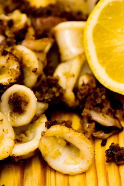 Fried squids ve shipirons ahşap plaka üzerinde limonlu