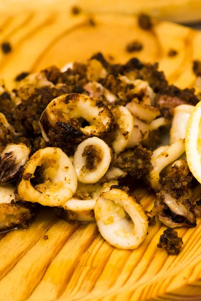Fried squids ve shipirons ahşap plaka üzerinde limonlu