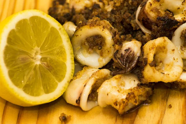 Fried squids ve shipirons ahşap plaka üzerinde limonlu