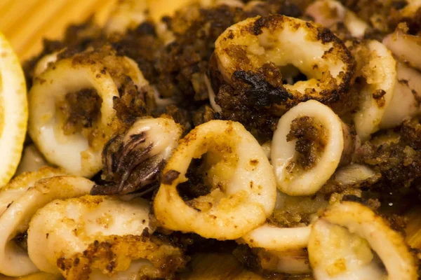 Fried squids ve shipirons ahşap plaka üzerinde limonlu