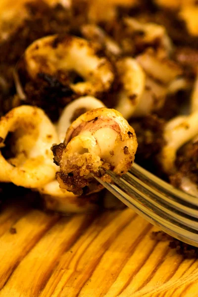 Calamares fritos y shipirons con limón en un plato de madera — Foto de Stock