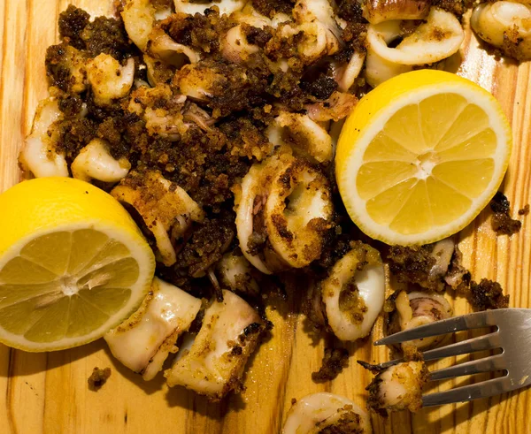 Fried squids ve shipirons ahşap plaka üzerinde limonlu