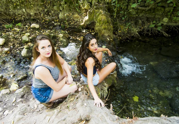 Zwei schöne Frauen in der Natur am Ufer eines Gebirgsflusses — Stockfoto