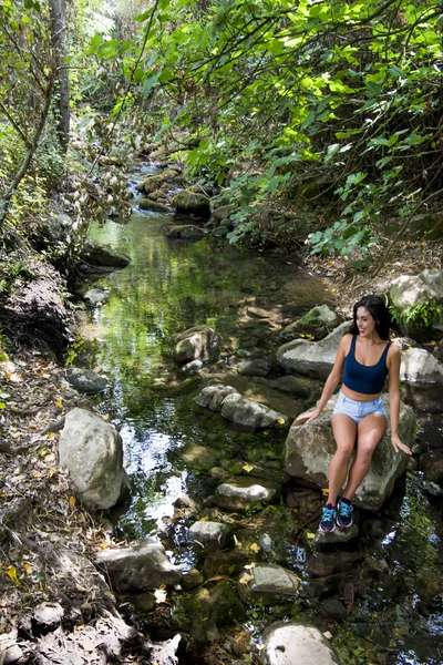 Hermosa mujer en la naturaleza en la orilla de un río de montaña — Foto de Stock