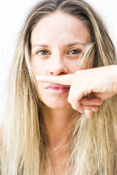 Portrait of the face of a beautiful blond woman  with her finger