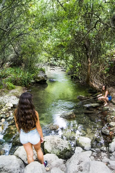 Две красивые женщины в природе на берегу горной реки — стоковое фото
