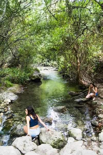 Duas mulheres bonitas na natureza na margem de um rio de montanha — Fotografia de Stock