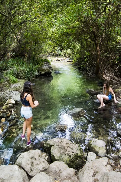Duas mulheres bonitas na natureza na margem de um rio de montanha — Fotografia de Stock