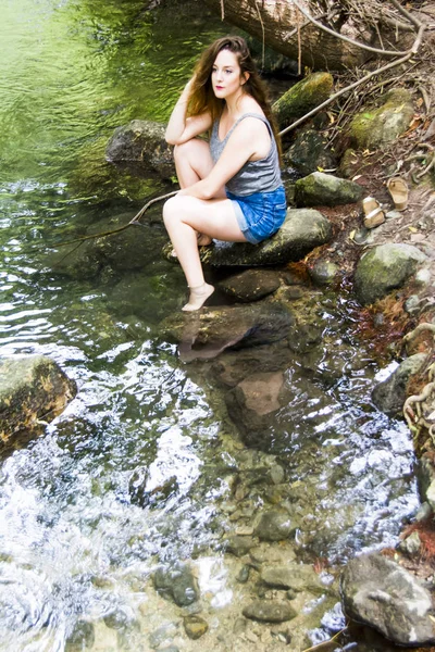 Mooie vrouw in de natuur aan de oever van een rivier berg — Stockfoto