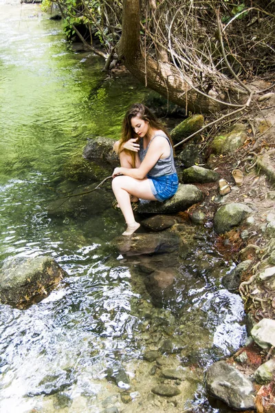 Mooie vrouw in de natuur aan de oever van een rivier berg — Stockfoto