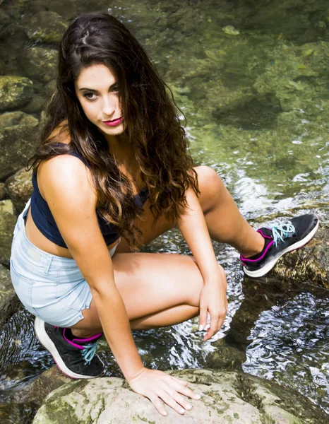 Mooie vrouw in de natuur aan de oever van een rivier berg — Stockfoto