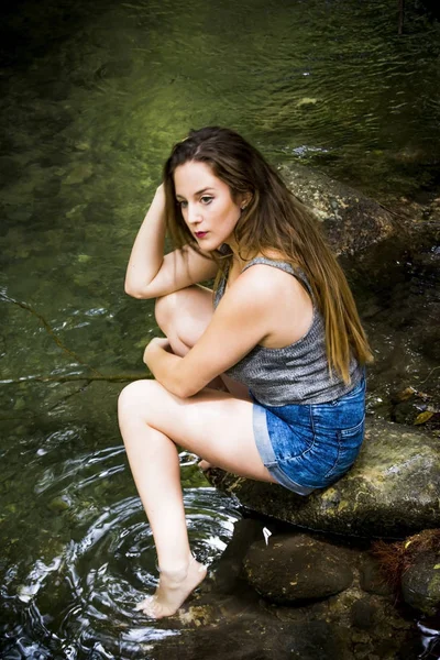 Mooie vrouw in de natuur aan de oever van een rivier berg — Stockfoto