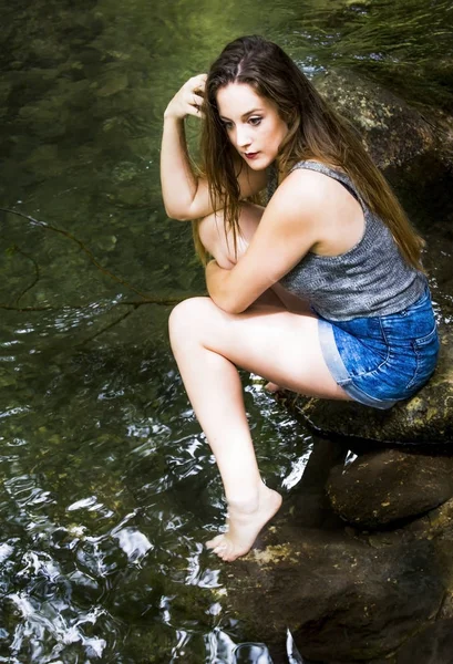 Mooie vrouw in de natuur aan de oever van een rivier berg — Stockfoto