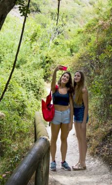 Doğada bir cep telefonu ile bir selfie yapıyor iki güzel kadın