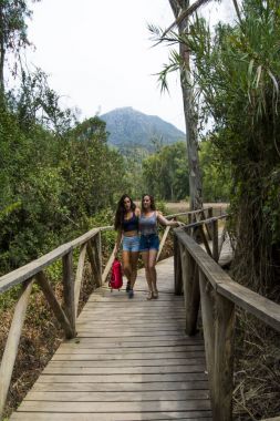 Doğada ahşap bir yolda mo hiking, iki güzel kadın