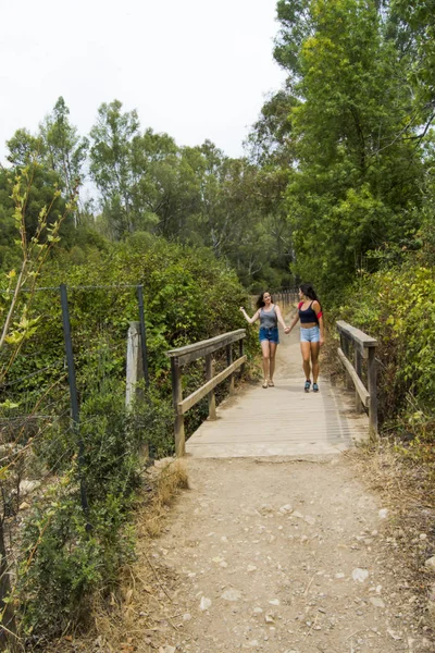 Dos hermosas mujeres que caminan en la naturaleza en un camino de montaña — Foto de Stock