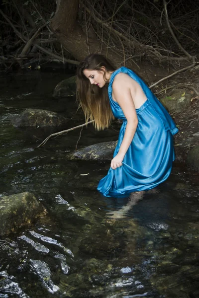 Hermosa mujer en la orilla de un río de montaña con una noche — Foto de Stock