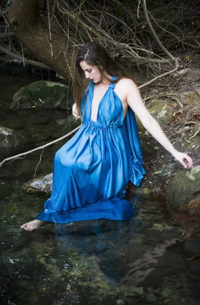 Mooie vrouw aan de oever van een rivier berg met een avond — Stockfoto