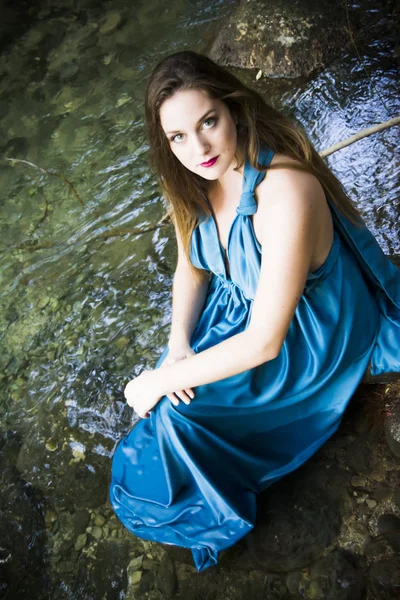 Hermosa mujer en la orilla de un río de montaña con una noche — Foto de Stock