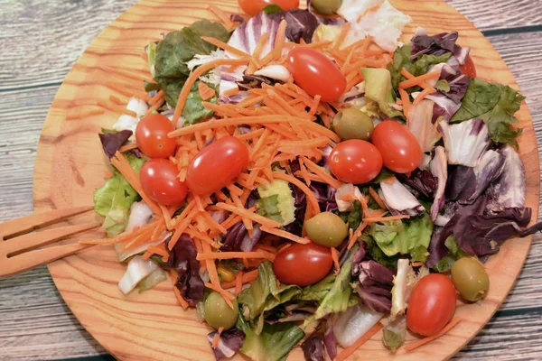 Salade fraîche dans une assiette en bois — Photo