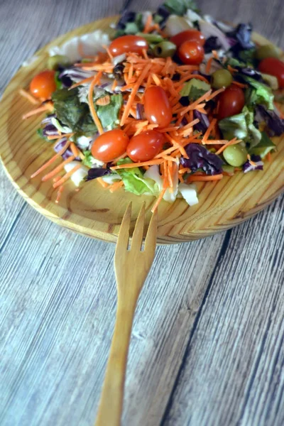 Ensalada fresca en un plato de madera —  Fotos de Stock