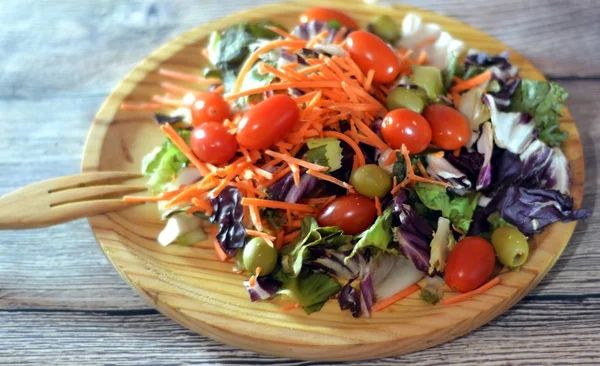 Čerstvý salát na dřevěné desce — Stock fotografie