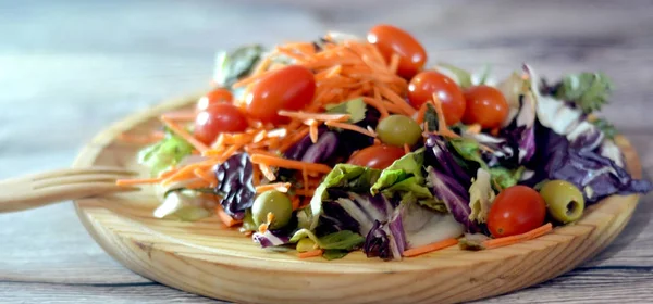 Свіжий салат на дерев'яній тарілці — стокове фото