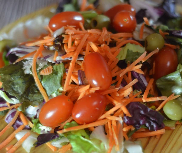 Ensalada fresca en un plato de madera —  Fotos de Stock