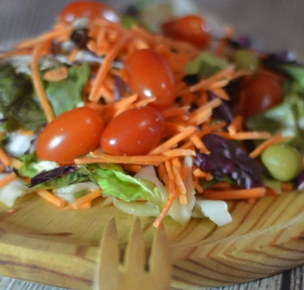 Insalata fresca su un piatto di legno — Foto Stock