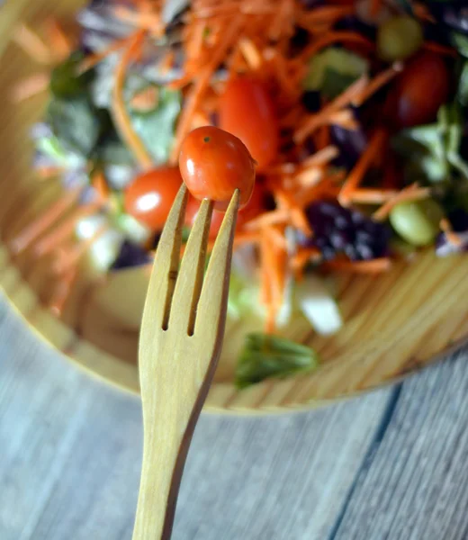 Ensalada fresca en un plato de madera —  Fotos de Stock