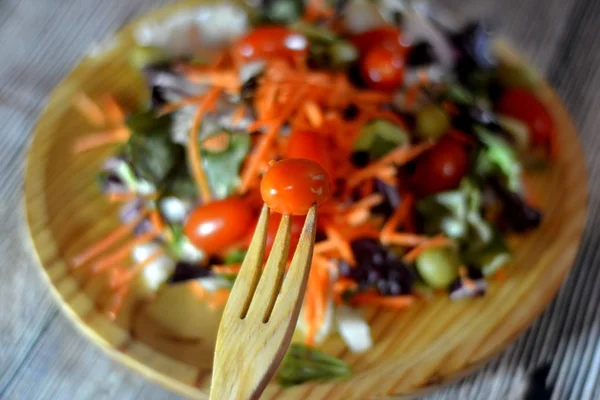 Frischer Salat auf einem Holzteller — Stockfoto