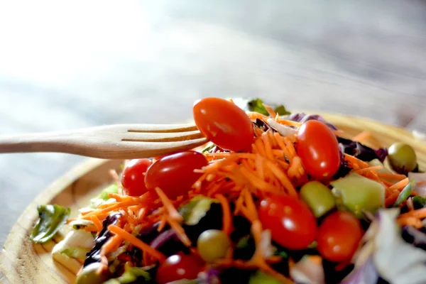 Ensalada fresca en un plato de madera —  Fotos de Stock