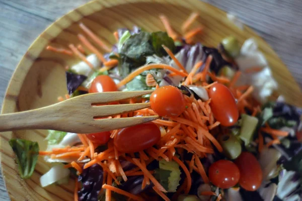 Insalata fresca su un piatto di legno — Foto Stock