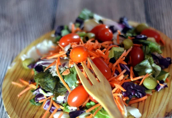 Ensalada fresca en un plato de madera —  Fotos de Stock