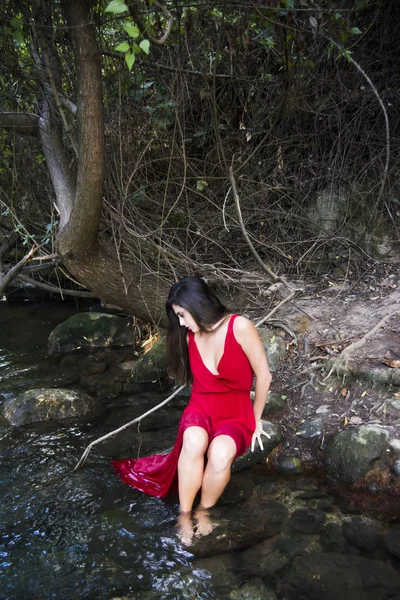 Mooie vrouw aan de oever van een rivier berg met een avond — Stockfoto